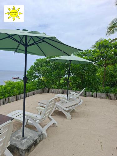 two chairs and an umbrella on the beach at DaRosa Del Mar in Santa Monica