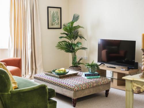 sala de estar con mesa de centro y TV en Chapel Court Apartment, en Barnard Castle