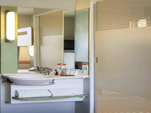 a bathroom with a sink and a mirror at Ibis Budget Valencia Alcasser in Silla