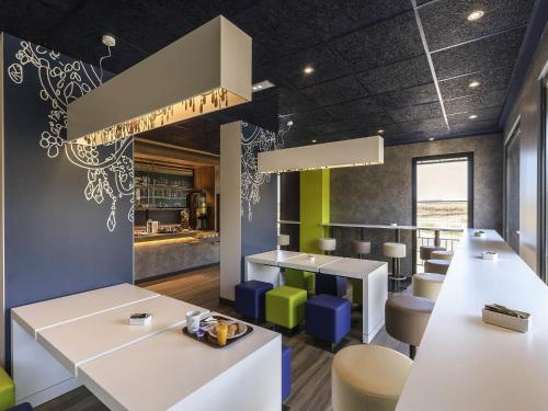 a dining room with white tables and chairs at Ibis Budget Valencia Alcasser in Silla