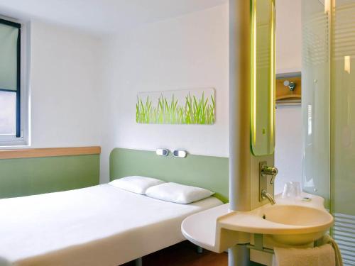 a small room with a bed and a sink at ibis budget Nimes Centre Gare in Nîmes
