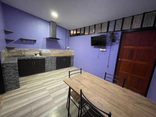 a kitchen with a wooden table and a wooden door at Lamai Home1 in Ko Yao Noi