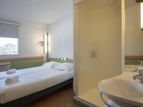 a hotel room with a bed and a sink at ibis budget Ajaccio in Ajaccio