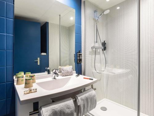a bathroom with a sink and a shower at ibis budget Saint Dié des Vosges in Saint Die