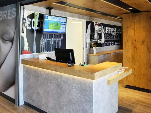 Una televisión o centro de entretenimiento en Ibis budget Les Sables d'Olonne