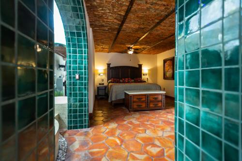 a bedroom with a bed in a room with a tile floor at Quinta Don Jose Boutique Hotel in Guadalajara