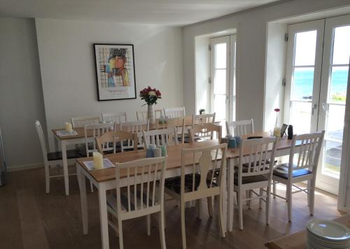 comedor con mesa y sillas en Badepensionat Sandloppen, en Sandvig