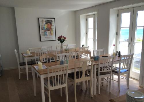 a dining room with a table and chairs at Badepensionat Sandloppen in Sandvig