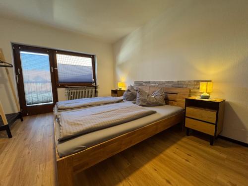 a bedroom with a large bed and a window at Zur goldenen Krone Pension Stadtallendorf in Stadtallendorf