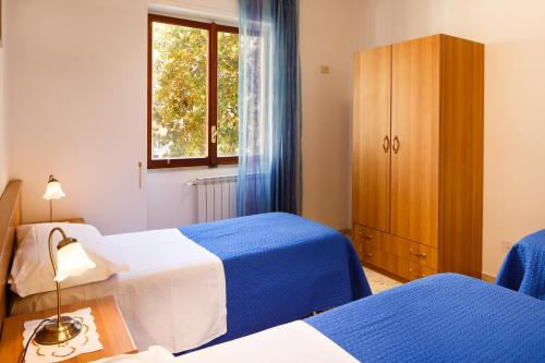 a bedroom with two beds and a cabinet and a window at Casa Nonna Netta in Sorrento