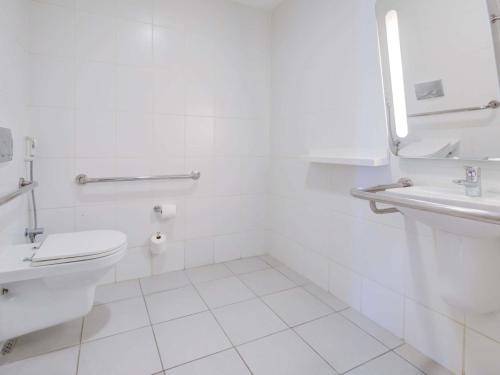 a white bathroom with a toilet and a sink at ibis budget Rio de Janeiro Nova America in Rio de Janeiro