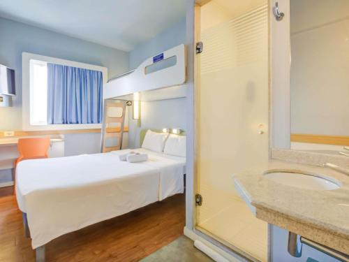 a hotel room with a bed and a sink at ibis budget Rio de Janeiro Nova America in Rio de Janeiro