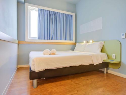 a bedroom with a bed with two towels on it at ibis budget Rio de Janeiro Nova America in Rio de Janeiro