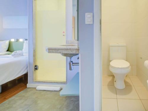 a bathroom with a toilet and a sink at ibis budget Rio de Janeiro Nova America in Rio de Janeiro