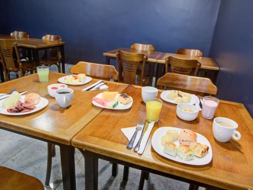 a wooden table with plates of food on it at ibis budget Rio de Janeiro Nova America in Rio de Janeiro