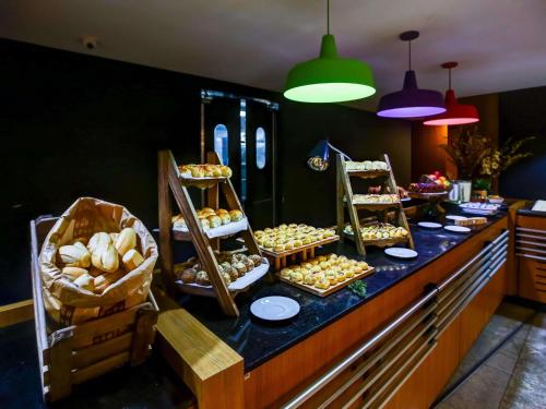 a buffet line with many different types of pastries at ibis budget Rio de Janeiro Nova America in Rio de Janeiro