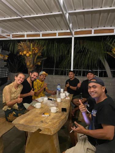 a group of people sitting around a wooden table at Eco Moringa Garden in Banyuwedang