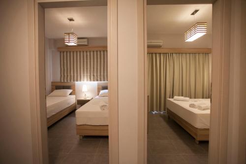 a bedroom with two beds and a mirror at Villa Ikaros in Ammoudia