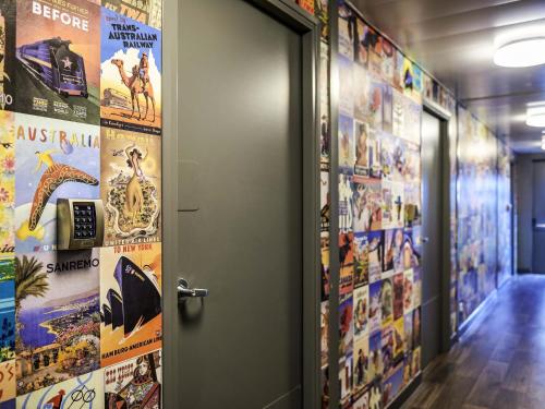 an open door in a hallway with posters on the walls at hotelF1 Genève Aéroport Ferney in Ferney-Voltaire