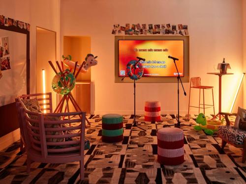 a living room with chairs and a flat screen tv at Mama Shelter Lyon in Lyon