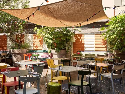 a restaurant with tables and chairs and plants at Mama Shelter Lyon in Lyon