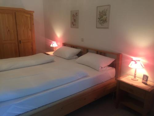 two beds in a bedroom with two lamps on tables at Ferienwohnung Karl - direkt im Ski- und Wandergebiet Spitzingsee in Spitzingsee