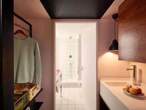 a bathroom with a sink and a bath room at Mama Shelter Paris East in Paris