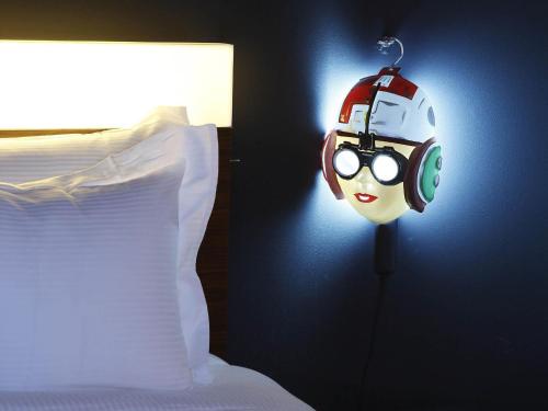 a bedroom with a bed with a helmet and glasses at Mama Shelter Paris East in Paris