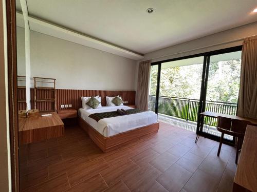 a bedroom with a bed and a balcony at Ningmas Casita Residence Villa by Sidhi Experiences in Ubud