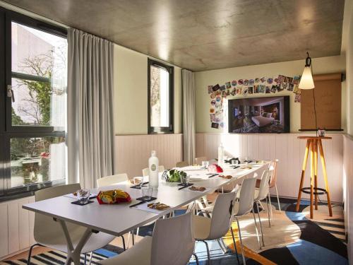 a dining room with white tables and white chairs at Mama Shelter Paris East in Paris