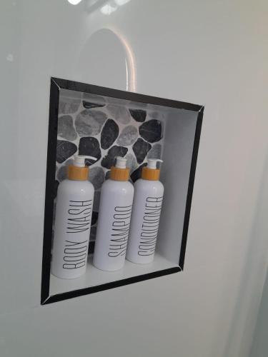 a group of four white bottles in a black box at Beachview 1 Bedroom 4 at Sandcastles in Ocho Rios