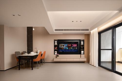 a dining room with a tv and a table with chairs at 海棠湾罗岚度假酒店-Haitang Bay Luolan Resort Hotel in Fenjietang