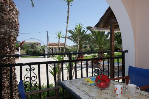 a table on a balcony with a view of the beach at Sofia - Yiota Studios & Apartments in Tsilivi