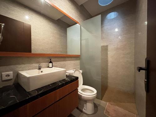 a bathroom with a sink and a toilet at Ningmas Casita Residence Villa by Sidhi Experiences in Ubud