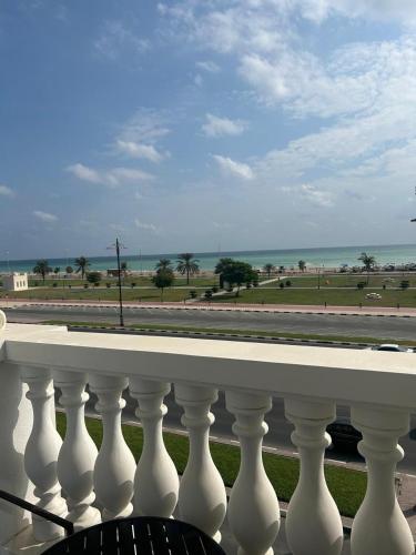 a white railing with a view of the ocean at East Coast Vacation Homes in Kalbā