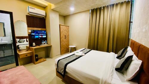 a hotel room with a bed and a television at Hotel RS Inn in Indore