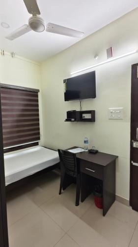 a room with a desk and a table and a window at UPPERCREST RESIDENCY PALA in Pala
