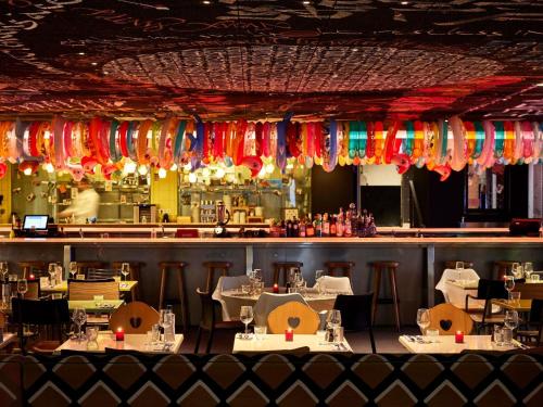 a restaurant with tables and chairs and a bar at Mama Shelter Bordeaux Centre in Bordeaux