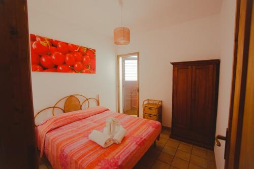 una camera con un letto e un dipinto di pomodori di SanvitoTour - Le Terrazze a San Vito lo Capo