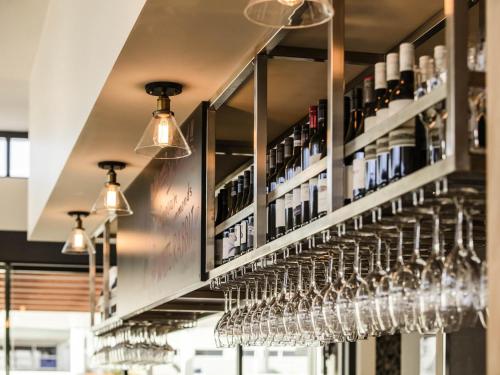 a bunch of wine glasses are lined up in a bar at Ibis Mackay in Mackay