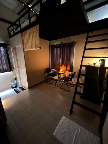 a room with a ladder and a table and chairs at Munchies Bed & Breakfast in Bangkok