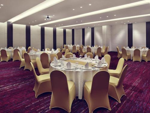 a conference room with tables and chairs and tablesktop at Mercure Karawang in Karawang