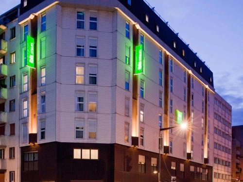 a building with green signs on the side of it at ibis Styles Paris Mairie de Montreuil in Montreuil