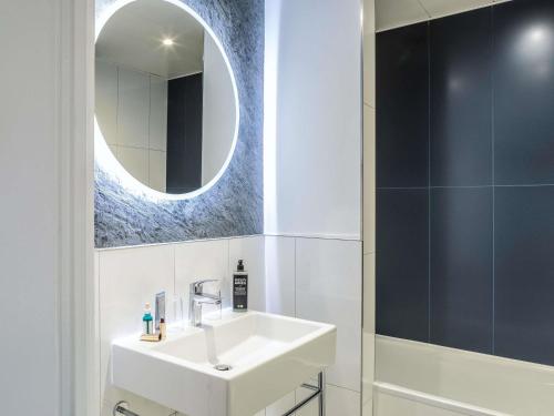 a bathroom with a white sink and a mirror at ibis Styles Paris Mairie de Montreuil in Montreuil