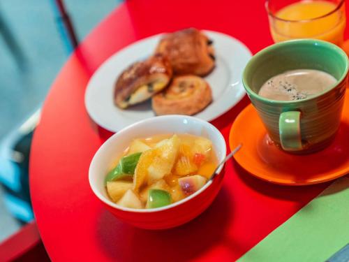 a red table with a bowl of food and a cup of coffee at ibis Styles Paris Mairie de Montreuil in Montreuil