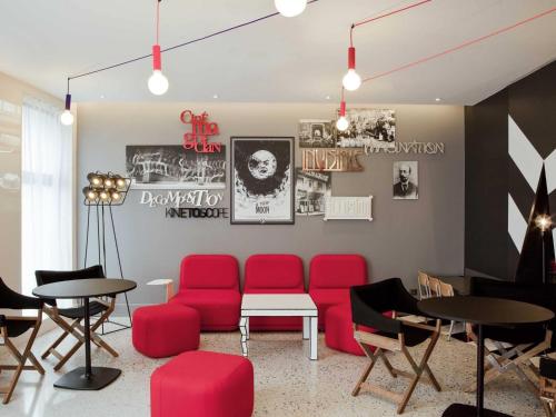 a waiting room with red chairs and tables at ibis Styles Paris Mairie de Montreuil in Montreuil