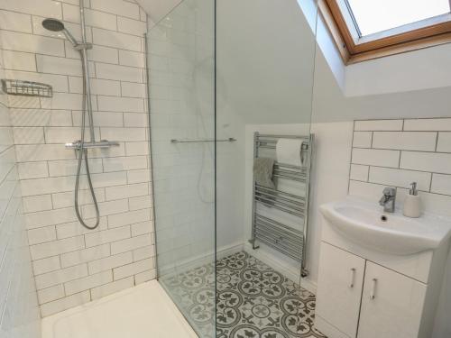 a bathroom with a shower and a sink at Treestumps in Benllech