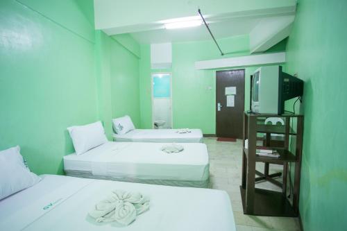 a room with two beds and a tv in it at GV Hotel - Dipolog in Dipolog