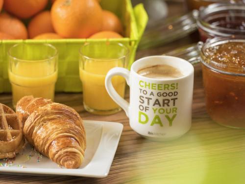 a table with a cup of coffee and a plate of croissants at Ibis Styles Milano Centro in Milan