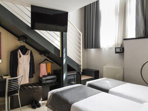 a bedroom with two beds and a staircase at Ibis Styles Milano Centro in Milan